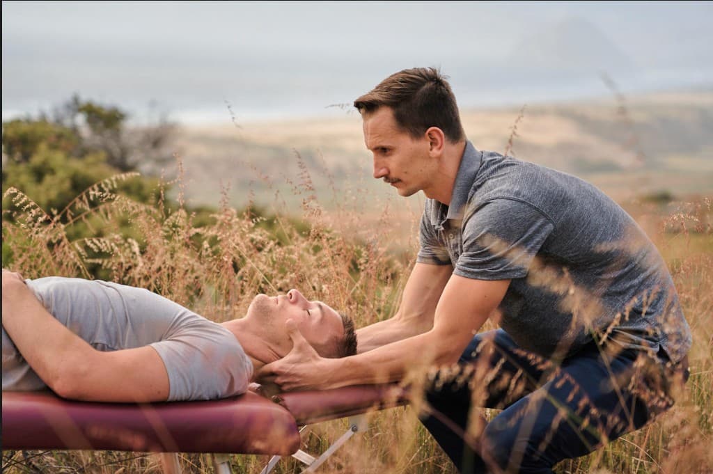 Dr. Kolofer providing chiropractic care in an outdoor coastal setting